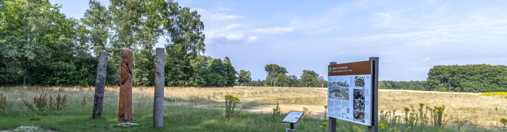 Een wandel- en fietstocht informatiebord met een overzichtskaart en wandelpaaltjes, ideaal voor routes direct vanaf de camping.